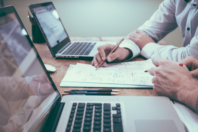 executivos escrevendo notebooks