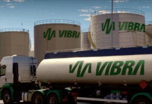 Foto de caminhão e tanques da Vibra Energia, com destaque para o logo da empresa