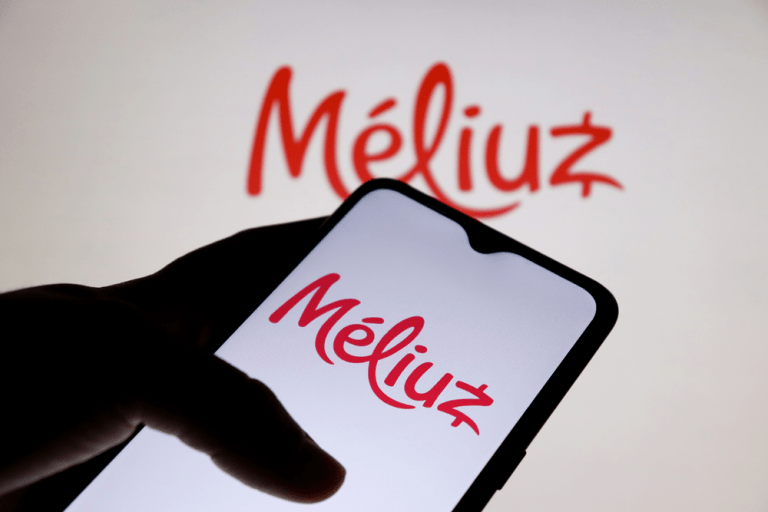 Foto de celular com logo do Méliuz, painel com logo ao fundo