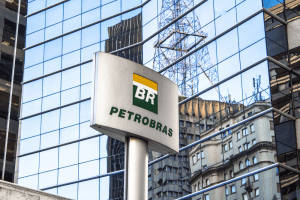 Foto de placa com logo da Petrobras e prédio da empresa ao fundo