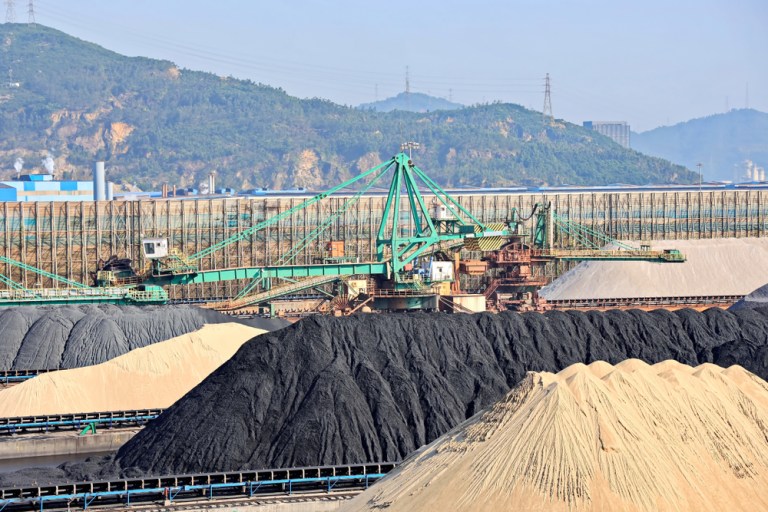 Porto na China com minério de ferro e guindastes