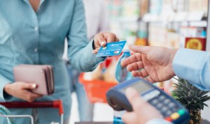 Pessoa repassando cartão de crédito para pagar alguma compra