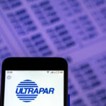 Tela de celular com o logo da Ultrapar na frente de papel com números