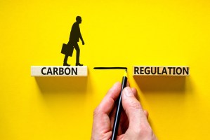 Uma plataforma com o nome Carbon e um executivo caminhando em cima dela, diante de uma linha feita a mão com lápis, ligando a outra plataforma com nome Regulation.