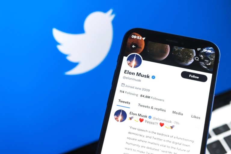 tela de celular exibe a conta do empresário Elon Musk no Twitter e, ao fundo, outra tela mostra o logotipo do Twitter