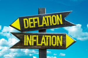 Placas de direção com os nomes deflation e inflation em sentidos opostos.