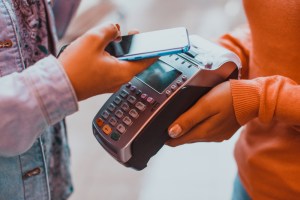 pessoa usa celular para fazer pagamento por aproximação