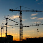 Guidastes de construção civil ao pôr do sol