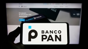 Telas de celular e computador com logo site do Banco Pan