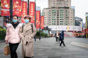 pessoas andam nas ruas de Chengdu, na China