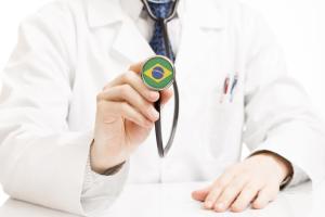 Médico segurando estetoscópio com estampa da bandeira do Brasil