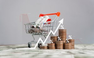 carrinho de compras e moedas com gráfico simulando inflação