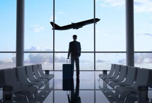 Homem com bagagem observa avião em aeroporto