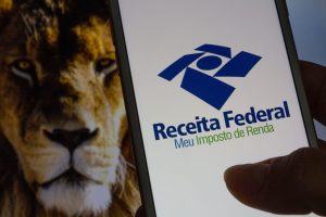 imagem de leão e app da Receita Federal para matéria sobre Imposto de Renda
