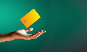 Arte com cartão de crédito amarelo no ar sobre mão aberta Lula