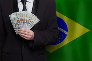 investidor com dólares e bandeira do Brasil