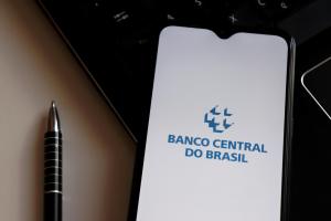 celular exibindo na tela o logotipo do Banco Central, instituição que deve cumprir a meta de inflação no Brasil
