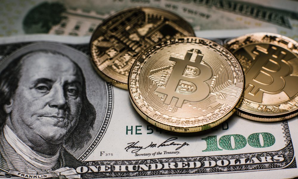 Moedas de Bitcoin sob cédulas de US$ 100