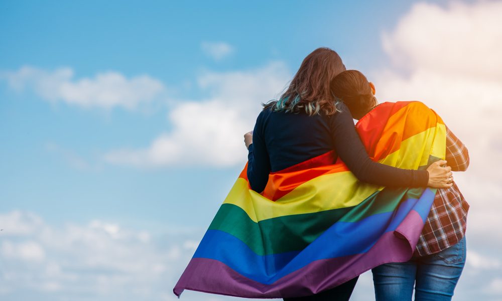 casal e bandeira LGBT