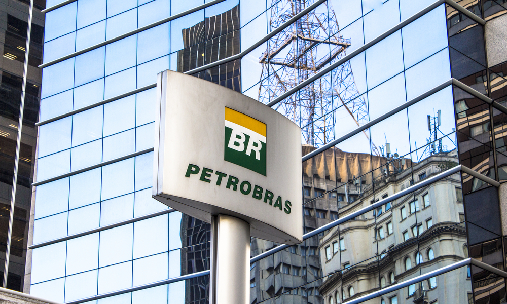 Foto de placa com logo da Petrobras e prédio da empresa ao fundo
